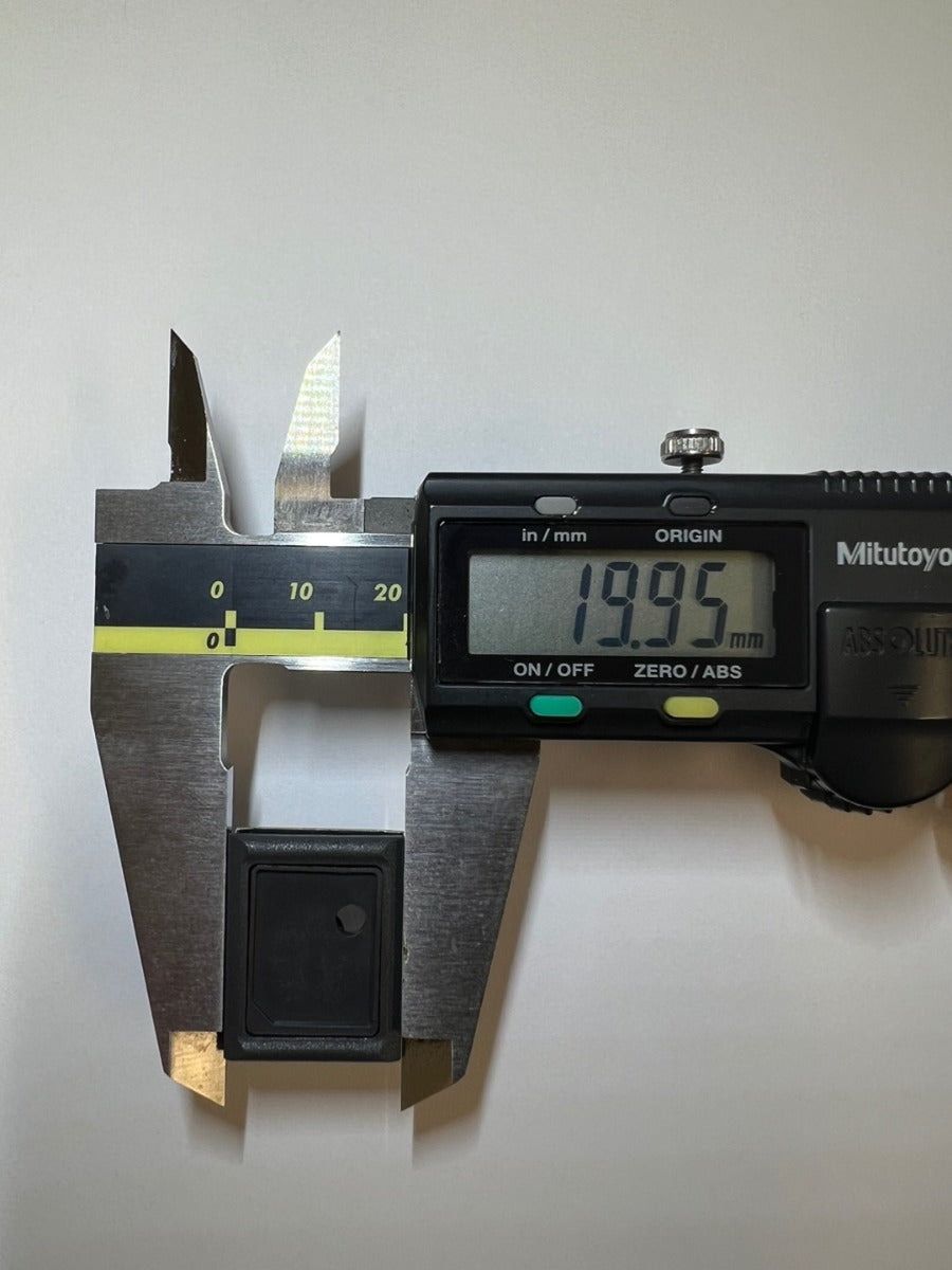 Measuring the push button's height at 19.95mm with a digital caliper.