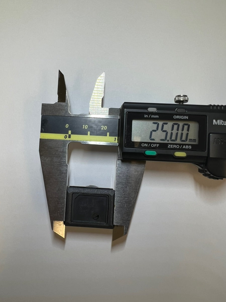 Measuring the push button's width at 25.00mm with a digital caliper.